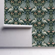 Load image into Gallery viewer, Antique Art Nouveau black and blue bird fabric peel and stick wallpaper on wall partially rolled up