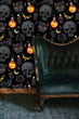 Load image into Gallery viewer, Black and orange Victorian gothic skull fabric peel and stick wallpaper with black sofa