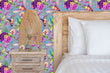 Load image into Gallery viewer, Purple and blue botanical floral hummingbird fabric peel and stick wallpaper with bed, nightstand and lamp