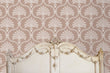 Load image into Gallery viewer, Pink Victorian antique damask fabric peel and stick wallpaper in room with bed