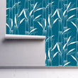 Load image into Gallery viewer, Blue bamboo botanical Asian fabric peel and stick wallpaper on wall partially rolled up