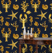 Load image into Gallery viewer, Blue and gold lobster and starfish nautical fabric peel and stick wallpaper with table and gold jars