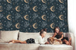 Load image into Gallery viewer, Witchy boho dark moon and stars fabric wallpaper with sofa, two girls and a dog