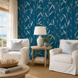 Load image into Gallery viewer, Temple Blue bamboo wallpaper by Pickwick & Elm in a bright coastal living room with white slipcovered chairs, woven rug, oak side table, and ocean views.