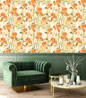 Load image into Gallery viewer, Orange cottage floral fabric peel and stick wallpaper in living room with velvet chair and coffee table

