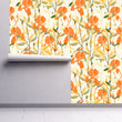 Load image into Gallery viewer, Orange cottage floral fabric peel and stick wallpaper on wall partially rolled up
