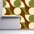 Load image into Gallery viewer, Green and brown vintage Mid-century Modern fabric peel and stick wallpaper on wall partially rolled up
