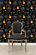 Load image into Gallery viewer, Black and orange Victorian gothic skull fabric peel and stick wallpaper with black chair
