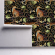 Load image into Gallery viewer, Black tropical cheetah print fabric peel and stick wallpaper on wall partially rolled up
