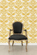Load image into Gallery viewer, Antique Victorian gold damask fabric peel and stick wallpaper with black chair
