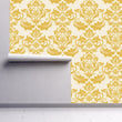 Load image into Gallery viewer, Antique Victorian gold damask fabric peel and stick wallpaper on wall partially rolled up
