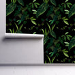 Load image into Gallery viewer, Dark moody botanical forest fabric peel and stick fabric wallpaper on wall partially rolled up.
