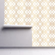 Load image into Gallery viewer, Gold antique geometric Art Deco fabric peel and stick wallpaper on wall partially rolled up
