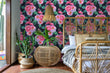 Load image into Gallery viewer, Dark black and pink tropical floral flamingo fabric peel and stick wallpaper with wicker bed, end table and plants
