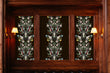 Load image into Gallery viewer, Black floral Chinoiserie antique Victorian fabric peel and stick wallpaper on wood wall with sconces
