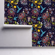 Load image into Gallery viewer, Blue and purple botanical floral hummingbird fabric peel and stick wallpaper on wall partially rolled up

