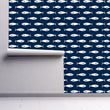 Load image into Gallery viewer, Navy blue and white nautical coastal fish swimming fabric peel and stick wallpaper on wall partially rolled up
