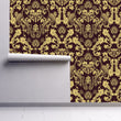 Load image into Gallery viewer, Ornate gold damask Victorian fabric peel and stick wallpaper on wall partially rolled up

