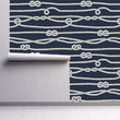Load image into Gallery viewer, Blue and white nautical rope and knots fabric peel and stick wallpaper on wall partially rolled up
