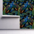 Load image into Gallery viewer, Black and blue dark topical botanical peacock fabric peel and stick wallpaper on wall partially rolled up
