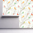 Load image into Gallery viewer, Colorful botanical bird fabric peel and stick wallpaper on wall partially rolled up
