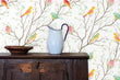 Load image into Gallery viewer, Colorful botanical bird fabric peel and stick wallpaper with cabinet, water pitcher and plate
