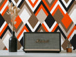Load image into Gallery viewer, Orange and brown geometric retro Mid-century modern fabric peel and stick wallpaper with radio and plant in vase
