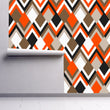 Load image into Gallery viewer, Orange and brown geometric retro Mid-century modern fabric peel and stick wallpaper on wall partially rolled up
