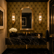 Load image into Gallery viewer, Black marble vanity, polished brass fixtures, and an arched mirror pair beautifully with Pickwick &amp; Elm's Hutton Art Deco wallpaper in this sophisticated powder room.
