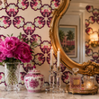 Load image into Gallery viewer, Close-up of Reese Way wallpaper by Pickwick &amp; Elm with a gold ornate mirror, pink peonies, crystal candlesticks, and marble vanity.

