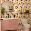 Load image into Gallery viewer, Bright pink cabinetry, brass accents, and Stella Road wallpaper by Pickwick &amp; Elm transform this colorful mid-century modern bathroom into a fun retro-inspired space.
