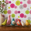 Load image into Gallery viewer, Colorful ceramic birds sit on a walnut console table against Pickwick &amp; Elm's Stella Road mid-century modern wallpaper featuring pink, lime green, and gray atomic-inspired floral motifs.
