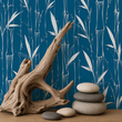 Load image into Gallery viewer, Temple Blue bamboo wallpaper by Pickwick &amp; Elm displayed behind natural driftwood sculpture and stacked river stones for a modern organic coastal styling vignette.
